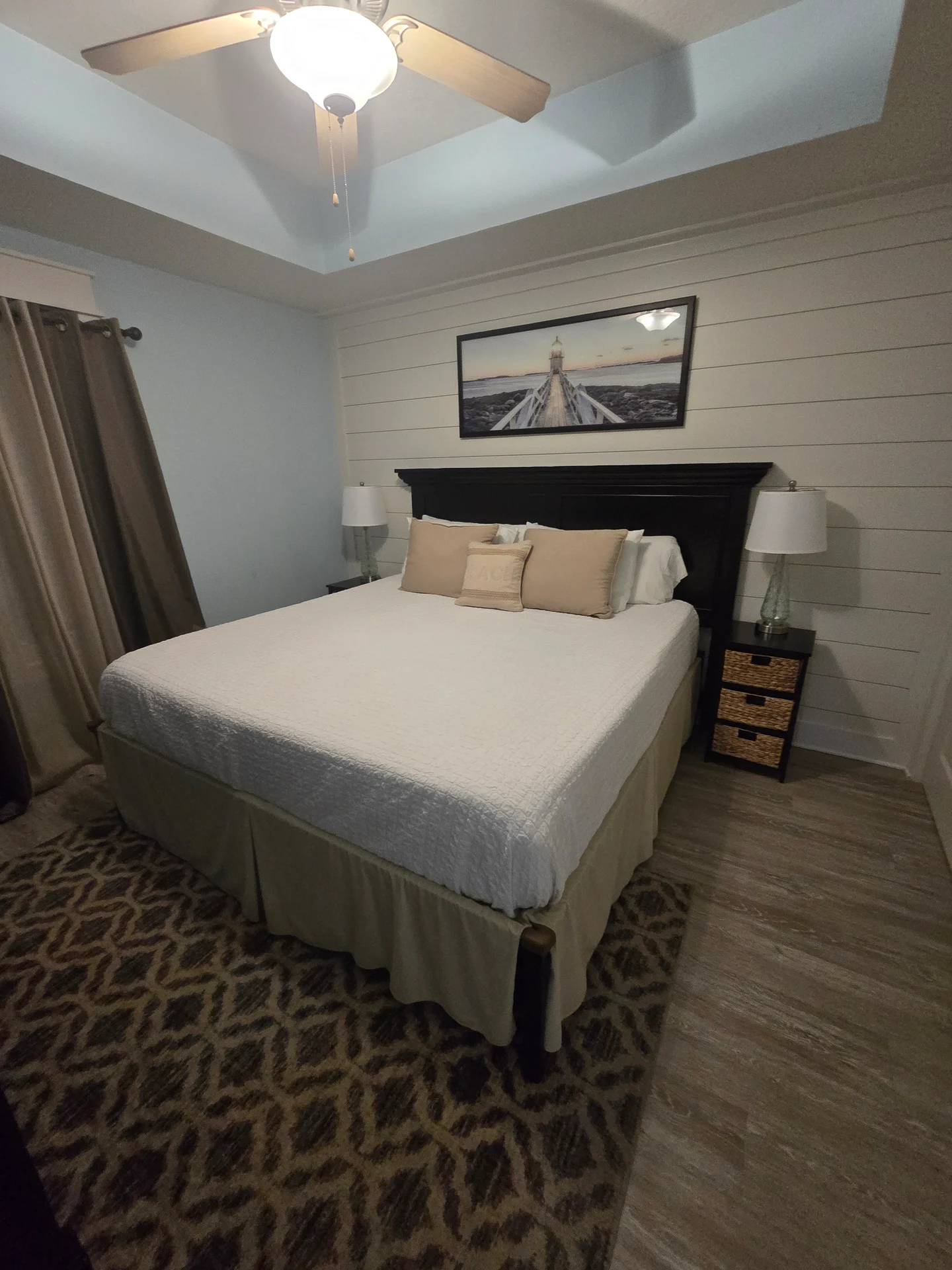 Bedroom with a made bed, neutral linens, and a dark headboard